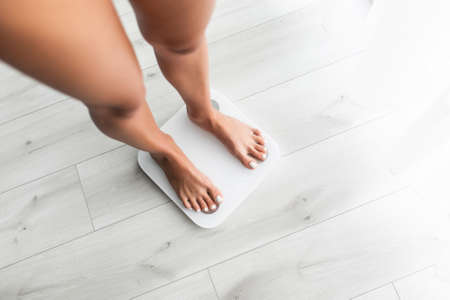 Feet of woman on weighting scale at home