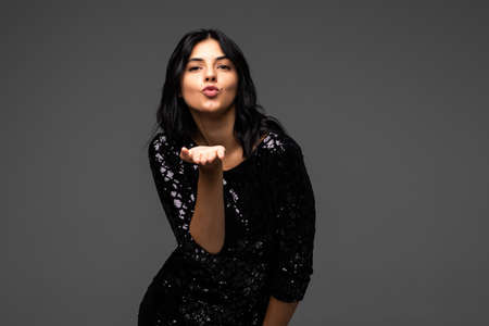 Gorgeous young woman blowing a kiss on a white backgroundの写真素材