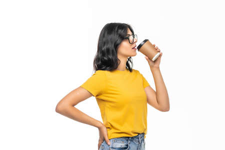 Young beautiful woman offers white cup of coffee isolated on gray background