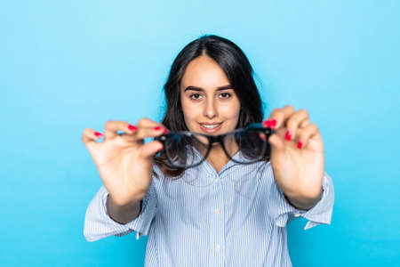 Young smiling woman with glasses on blue background