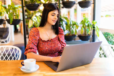 Beautiful hipster woman using laptop at cafeの写真素材