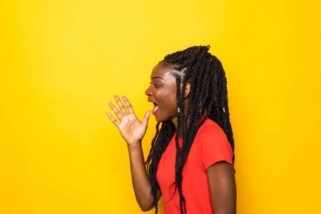 Young beautiful african woman screaming excited standing isolated over yellow background.