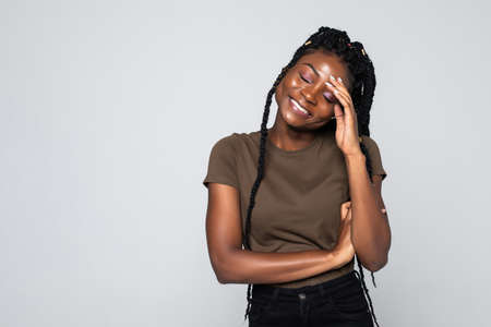 Portrait of a young african american woman with smile isolated on gray backgroundの写真素材