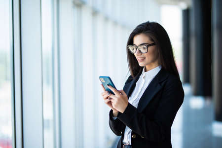 Young business woman use phone for text or surfing in internet in modern office.の写真素材
