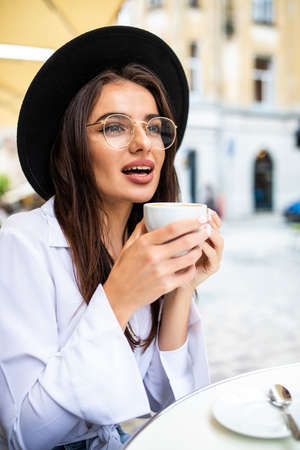 Woman drinking coffee at street cafe. Natural lightの写真素材