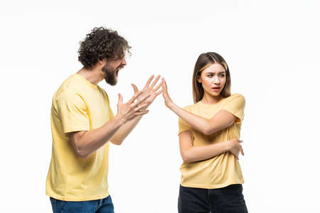 Closeup portrait of young angry couple, man, woman, screaming at each other, blaming for problem, isolated on white background. Marriage difficulties concept, negative emotions, expressions, feelingsの写真素材