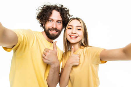 Attractive couple taking a selfie together on white backgroundの写真素材