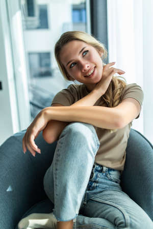Young woman resting in rocking chair at homeの写真素材
