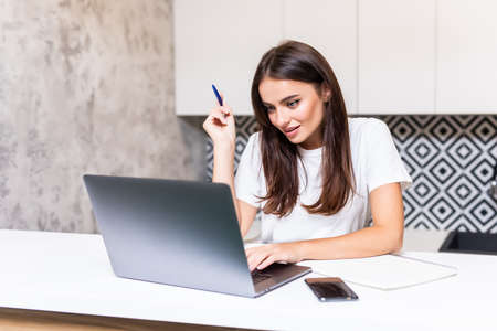 Happy casual entrepreneur working on line typing with a laptop at home