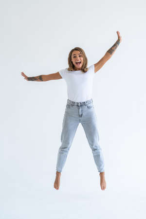 Young woman jumping isolated over white background