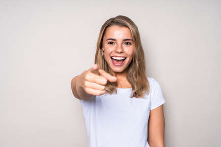 Young beautiful happy caucasian woman pointing on you, isolated on white