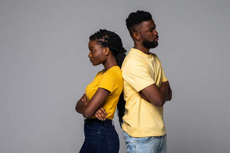 Portrait of an upset young afro american couple standing with arms folded isolated over white backgroundの写真素材