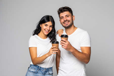 Portrait of a gorgeous young woman enjoying a cup of coffee with her boyfriend in a studioの写真素材