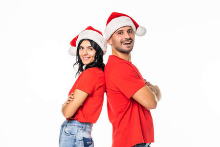 Young happy couple in Christmas hats. Isolated over white backgroundの写真素材