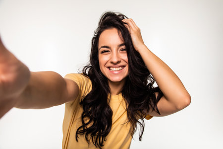 Beautiful young woman is making selfie photo with smartphone.の写真素材