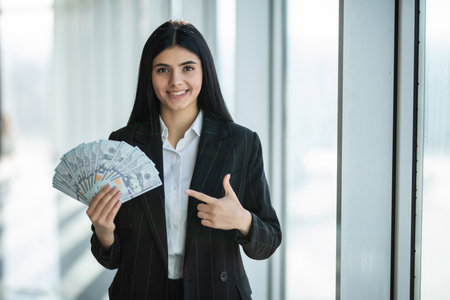 Happy business woman money pack banknotes on office