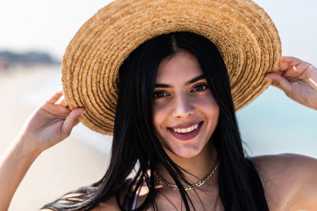 Lifestyle Image of carefree traveling smiling woman straw hat spending her leisure time on the beach. Summer mood.の写真素材