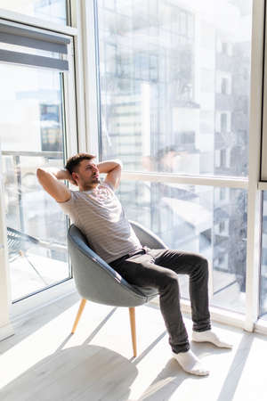 Rear view of man relaxing on chair at home