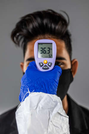 Doctor measuring man's temperature on white background, closeup.の写真素材