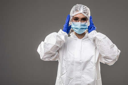 Woman wearing gloves with biohazard chemica protective suit. Isolated on white background.