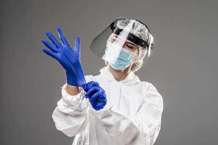 Woman wearing gloves with biohazard chemica protective suit. Isolated on white background.