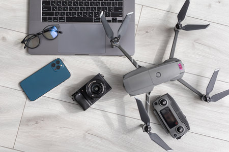 Dji mavic air on a wooden background, accessories for drones, phone and laptop near accumulatorsのeditorial素材