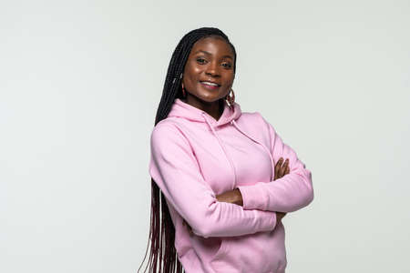 Young african woman with crossed hands on white background