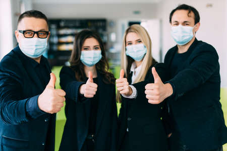 Portrait of skilled smart business persons giving thumbup in workplace workstation wearing safety...
