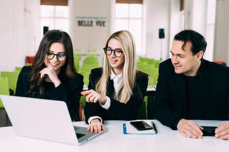Successful businessteam of three sitting in office and planning work