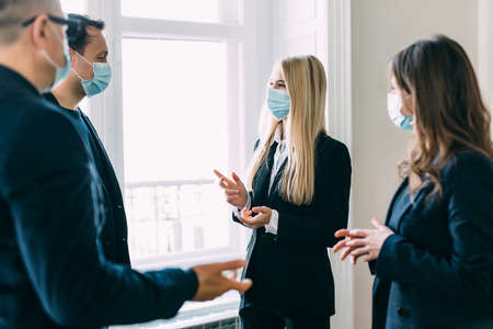 diverse business worker discuss and meeting while Wearing Medical Mask as protection from corona virus. New normal office working. Group of multiethnic people in business reopen. flu prevent healthyの写真素材