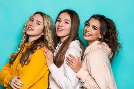 Three young women in casual clothing standing isolated on white background