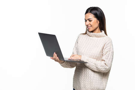 Young smiling confident woman using laptop computer and looking camera isolated over white