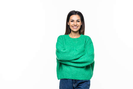 Attractive smiling young woman with long red hair hugging herself over white backgroundの写真素材