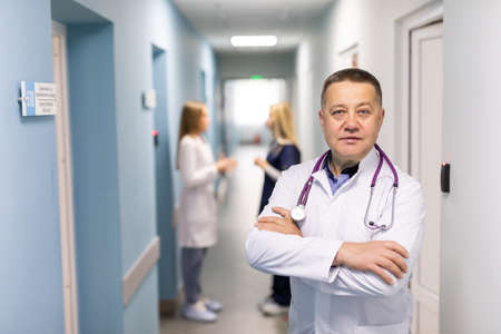 Medical team on hospital corridor mid-adult doctor in front smiling.の写真素材
