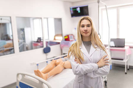 Doctor teacher in front of simulation room in hospital. Medical teach.