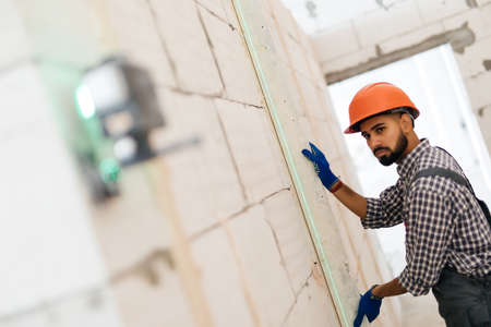 Laser level measuring tool and tape measure hand hold drill for accuracy on wood wallの写真素材