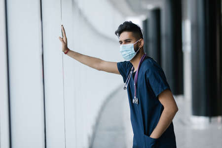 Portrait of a smiling Asian Indian male medical doctor at hospital.