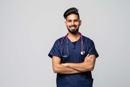 medicine, profession and healthcare concept - smiling indian male doctor in white coat with stethoscope over gray backgroundの写真素材