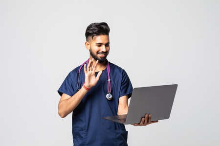 Indian Doctor with laptop make video call isolated on white backgroundの写真素材