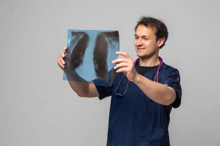 Portrait of a doctor looking at x-ray against a white backgroundの写真素材