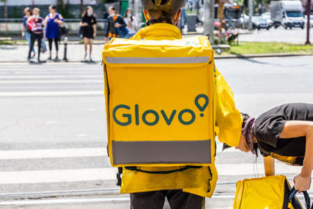 Juny, 2021 - Bucharest, Romania: Glovo food delivery courier delivers food in Bucharest, Romania.のeditorial素材