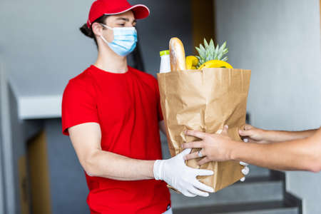 online grocery shopping service concept - delivery man with food boxの写真素材