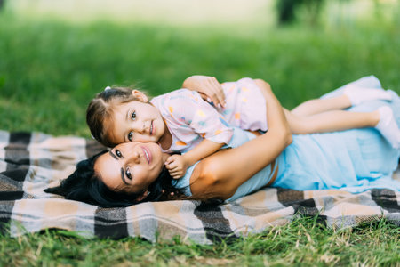 happy family mother and child daughter in nature Park in summer on green grassの写真素材
