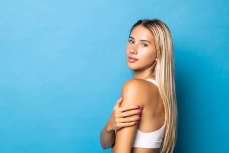 Sporty young girl posing on blue background. Beautiful fit woman.の写真素材