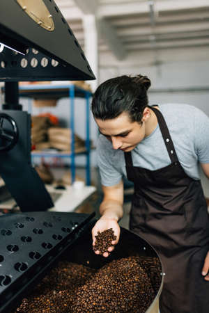 Baking coffee. Roasted Coffee beans before next step in professional roasting coffee machineの写真素材