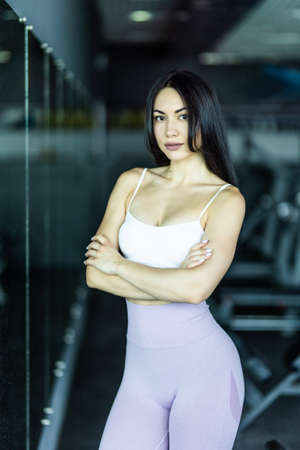 Young woman in sportswear taking a walk in the cross fit gym. Fitness female getting ready for intense crossfit workout.の写真素材