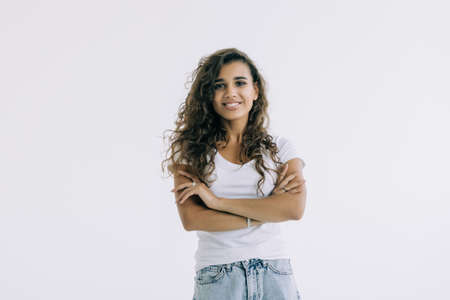 Portrait of a happy woman standing with arms folded isolated on a white backgroundの写真素材