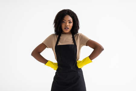 Cleaning concept. Young african woman in green apron on white backgroundの写真素材
