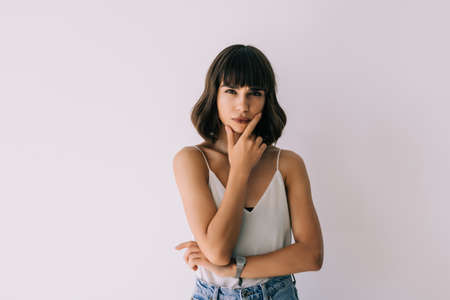 Happy woman thinking and looking sideways isolated on a white backgroundの写真素材