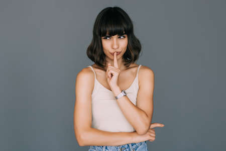 Pretty woman making silence gesture over gray backgroundの写真素材